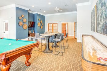 A game room with a pool table and a bar